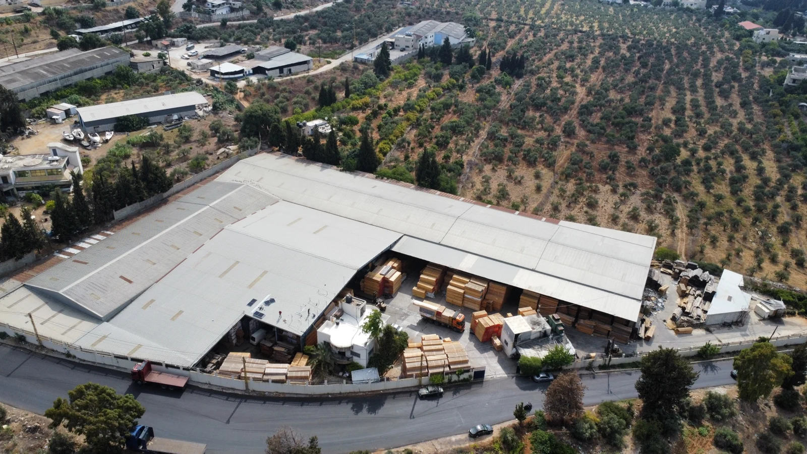 Aerial view of UTC’s Ras Maska warehouse, timber stacks and surrounding hillside